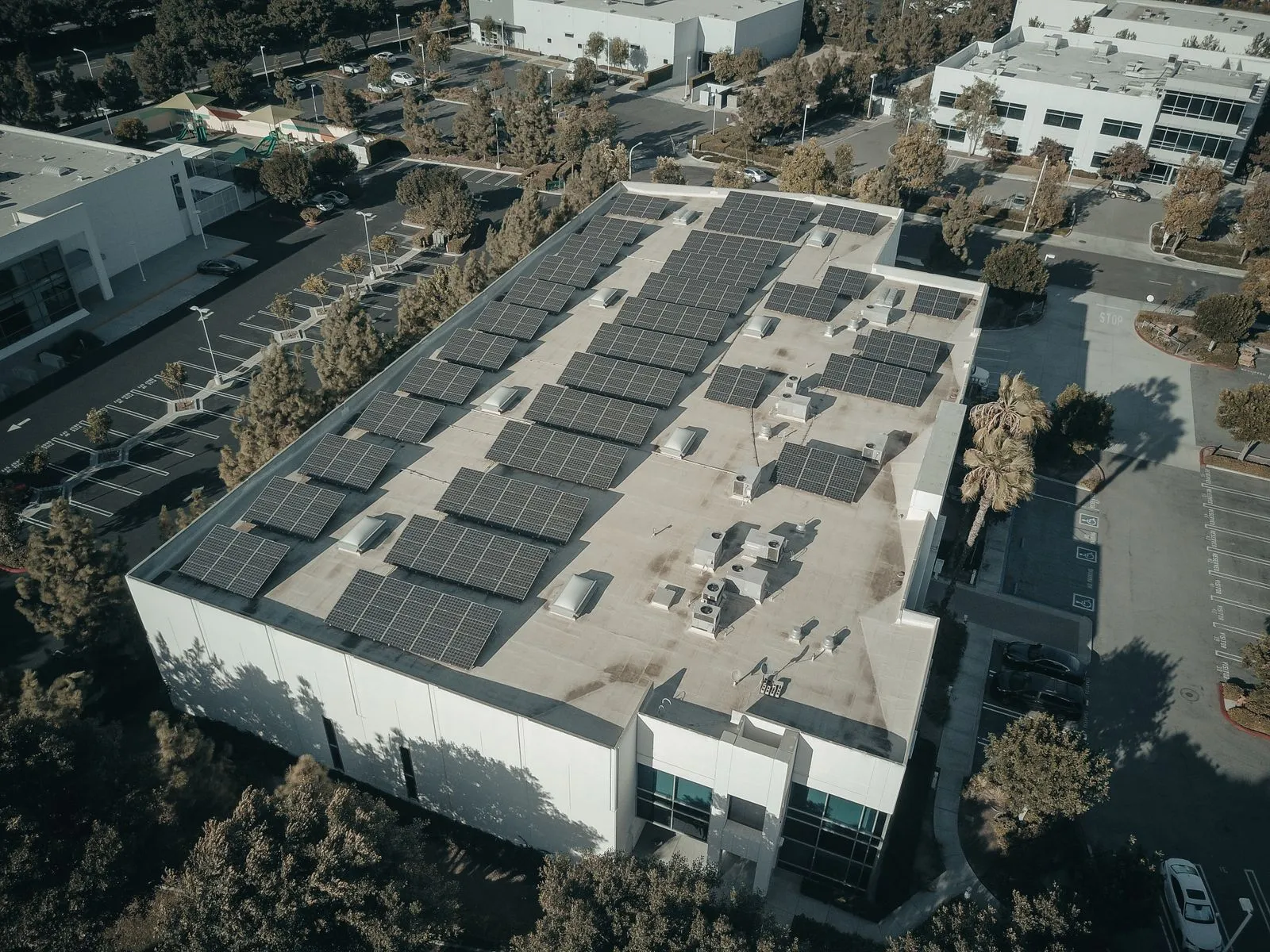Vue aérienne d'une toiture d'entreprise couverte de panneaux solaires en bord de mer